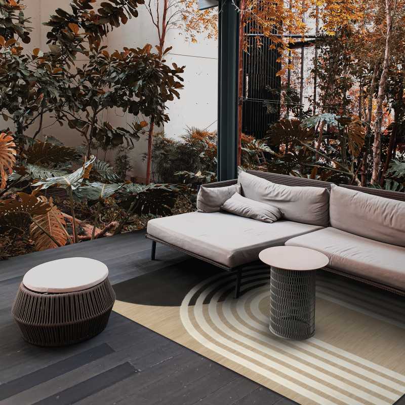 Tappeto Costa beige e bianco con motivo geometrico, perfetto per arredamento outdoor moderno su terrazza con divano e tavolini.